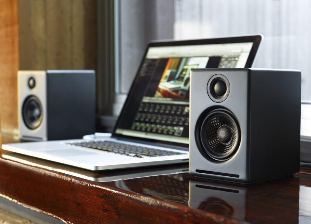Powered stereo speakers connected to a turntable and streaming setup.