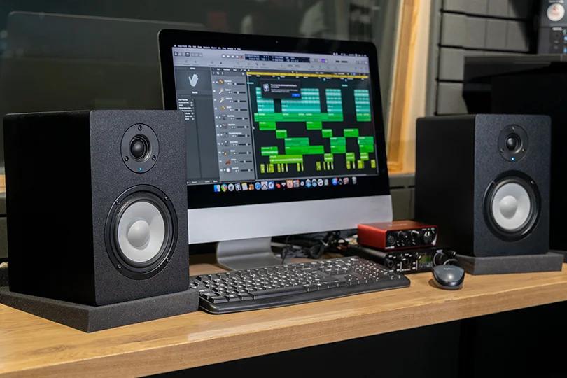 Near-field monitor speakers positioned on a desktop for precise listening.